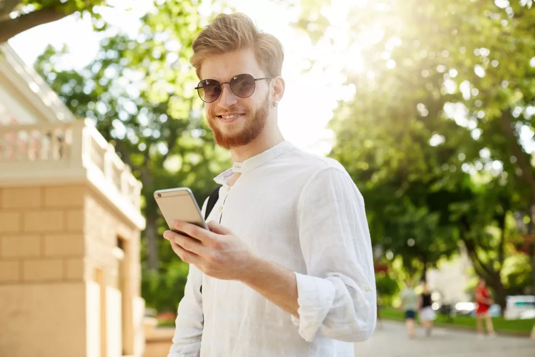 Fiatal férfi a telefonján ellenőrzi a szakmai profilját